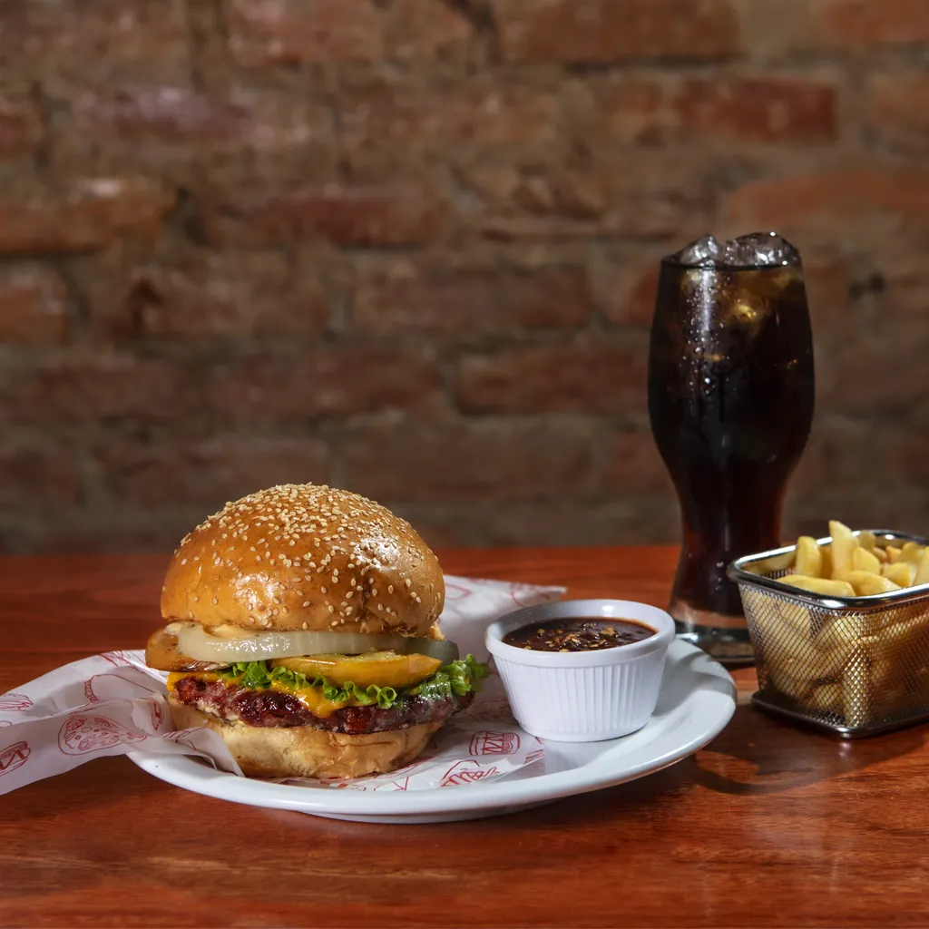 Hamburguesa artesanal de picaña con queso, lechuga y papas fritas en Herencias de Mãe, Leticia.