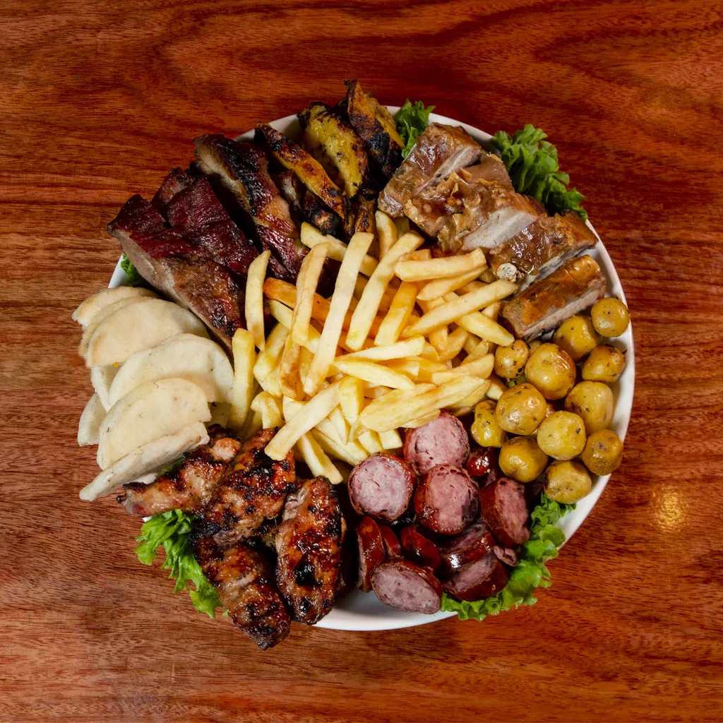 Picada mixta de asados al barril con carnes, chorizo, papas fritas y papas criollas en Herencias de Mãe, Leticia.